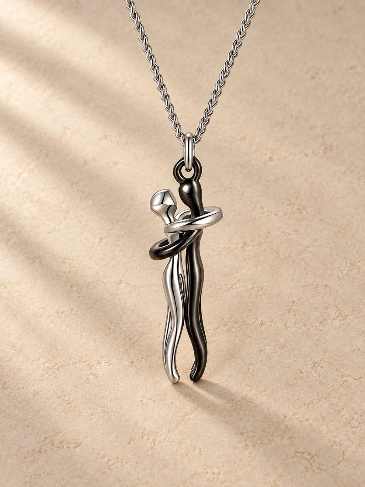 Hug necklace in black, embracing figures pendant